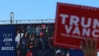 A man holds up a Trump-Vance sign at a rally by former president Donald Trump in Mosinee, Wisconsin