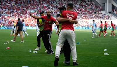 Fans invade pitch and throw objects at players after Argentina net 116th-minute equaliser in Olympic opener