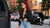 Dua Lipa cuts a stylish figure in a plunging black blouse