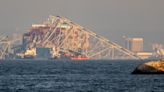 Demolition crews cutting into first pieces of Baltimore bridge as ship remains in rubble