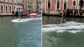 Tourists filmed surfing along canals in Venice