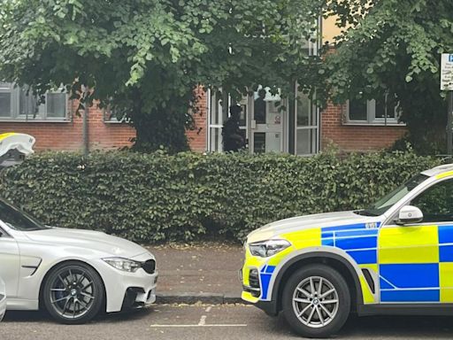 Armed police at block of flats as officers close road