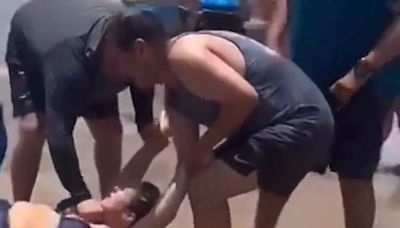 Chilling moment shark watches as bleeding woman is rescued