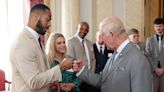 The King breaks convention with a fist bump at Buckingham Palace, while greeting Prince's Trust Awards winners