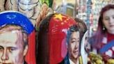 Traditional Russian nesting dolls depict Vladimir Putin (L) and his Chinese counterpart Xi Jinping at a gift shop in Moscow