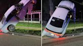 Car crashes and lands vertically on street sign, woman arrested for drunken driving