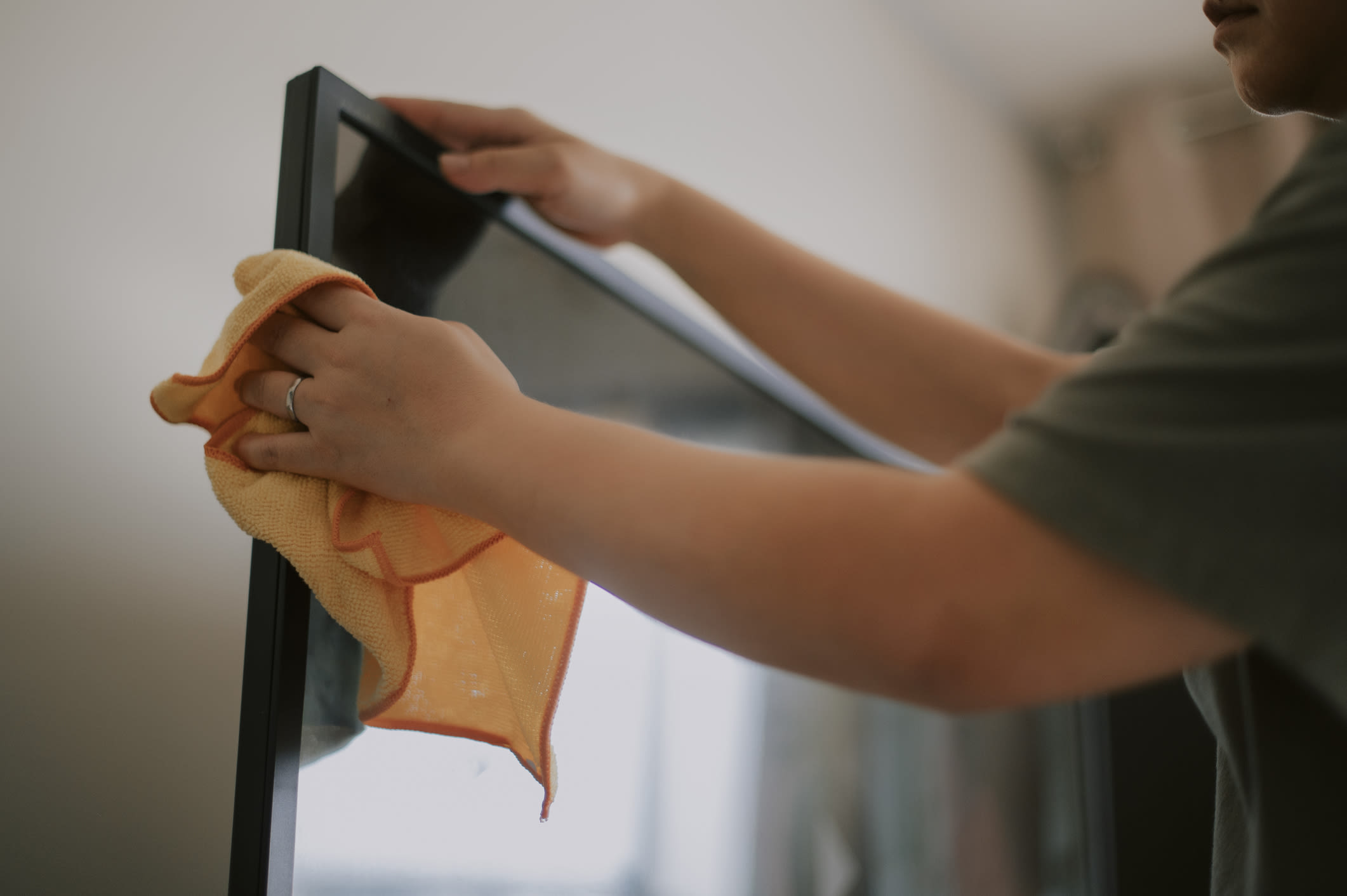 How do I clean a flat-screen TV covered with fingerprints?