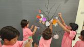 Maverick children place leaves of encouragement on Hope Tree for cancer patients