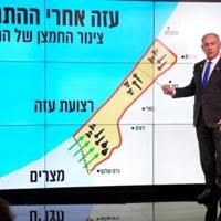 Israeli Prime Minister Benjamin Netanyahu points at a map of the Gaza Strip during a news conference in Jerusalem