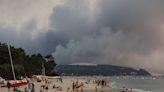 Photos of European heatwave show a stark juxtaposition: Beachgoers flocked to the ocean to cool off as smoke from nearby fires billow behind them