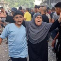 A woman reacts as people search for survivors after Israeli bombardment at Bureij refugee camp, central Gaza