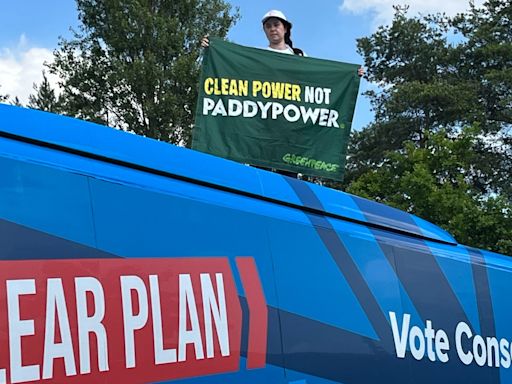Greenpeace protester mounts Tory bus demanding ‘clean power not Paddy Power’