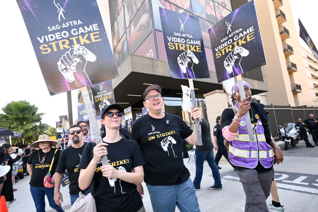 SAG-AFTRA Hits Picket Line At Warner Bros. Demanding “Baseline Of Respect” From Major Video Game Companies