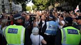 Protesters wearing tops with Southport victims faces descend on London