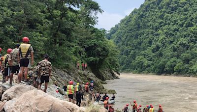 Rescuers recover first body after buses swept into river in Nepal