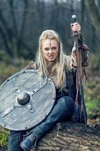 Blonde viking warrior woman in forest with shield and sword in hand ...