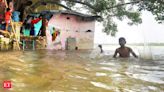 Two men, in flood-ravaged Lakhimpur Kheri, walk home with their sister's body - The Economic Times