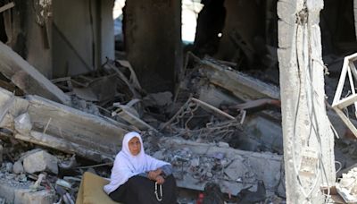 Palestinos de regreso a un campo de refugiados de Gaza deambulan entre las ruinas