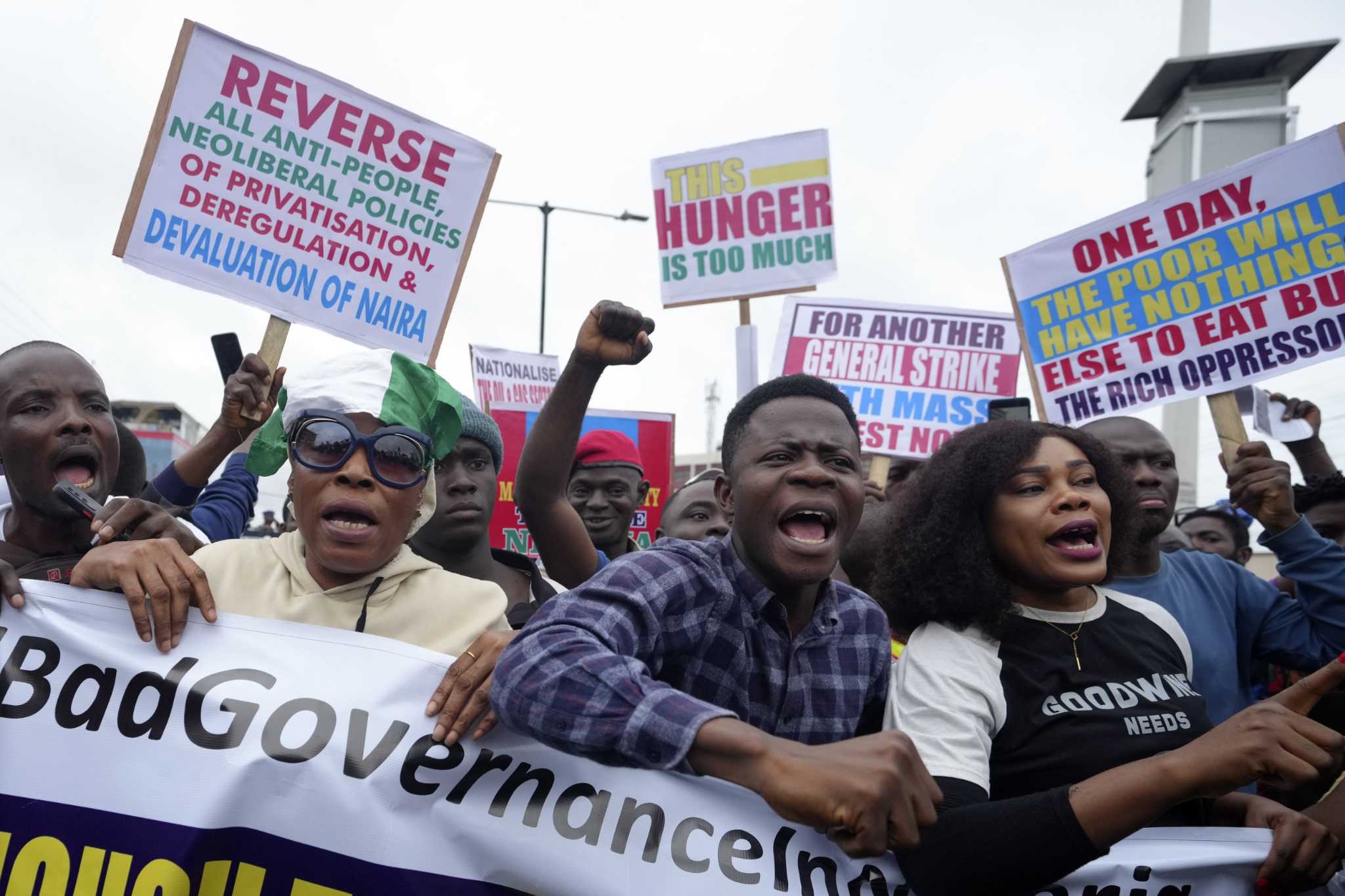 Police fire gunshots and tear gas to quell mass protests over Nigeria's economy. At least 2 killed