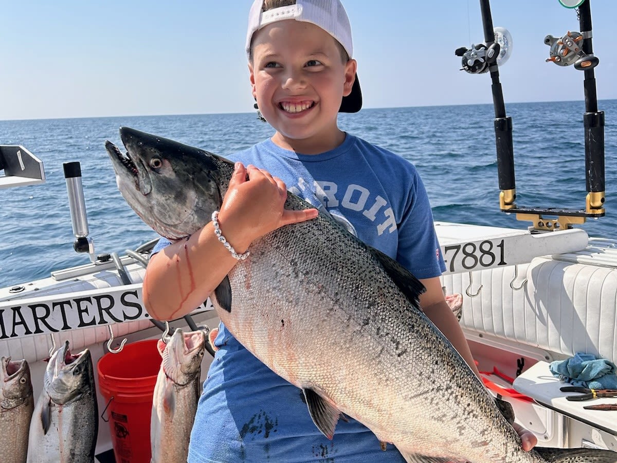 Young man embraces the utter fun of fishing; catching a really big fish helps