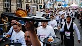 Paris waiters race through the streets to celebrate French capital's life and soul ahead of Olympics