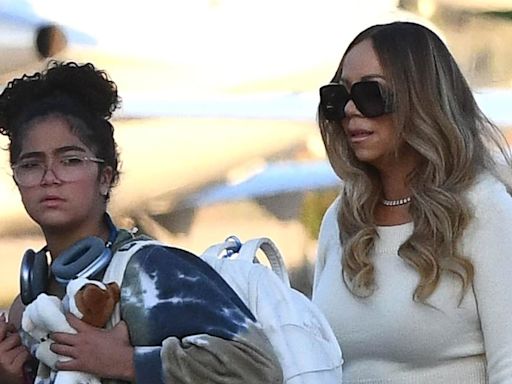 Mariah Carey teases a hint of her tummy in a beige top and maxi skirt