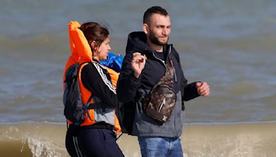 Migrant with Louis Vuitton manbag is seen trying to cross the Channel