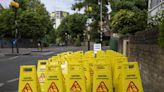 Campaigners set up signs outside polling booth saying 'Caution, Slippery Politicians'