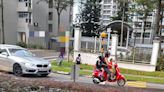 Woman rides scooter with two children in Queenstown, girl is not wearing helmet