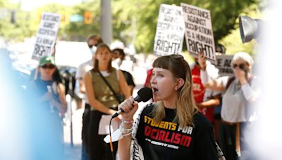 Protest against Israel occurs with backdrop of graduating UGA students taking pics at Arch