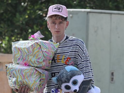 Machine Gun Kelly carries presents as he departs toy store