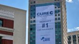 Whale mural covered by advertisement again, this time for Cure Auto Insurance