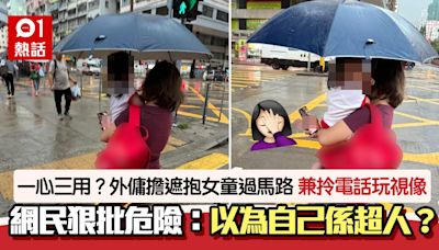 外傭擔遮抱女童過馬路+拎電話視像 網民斥危險：跌都無手撐地下