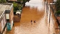 Aerial view of people walking through a flooded street at the Navegantes neighborhood in Porto Alegre, Rio da Grande do State, Brazil