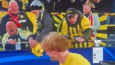 Borussia Dortmund fan appears to steal a Julian Brandt shirt from a supporter in a wheelchair after their Champions League win over Atletico Madrid... as team-mate Marius Wolf ...