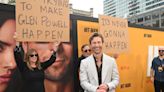 Glen Powell jokes he is 'kept humble' by his parents after they held signs up at his premiere
