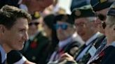 Canadian Prime Minister Justin Trudeau crouched down to talk to veterans