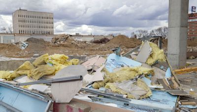 With high winds and drifting debris, how is trash from Moorhead Center Mall demolition contained?