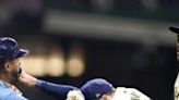 ...the Milwaukee Brewers holds back Jose Siri of the Tampa Bay Rays who attempts to go after Brewers pitcher Abner Uribe in a Major...