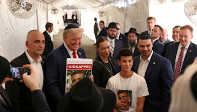 Trump slammed for grinning while holding picture of kidnapped American on October 7 anniversary