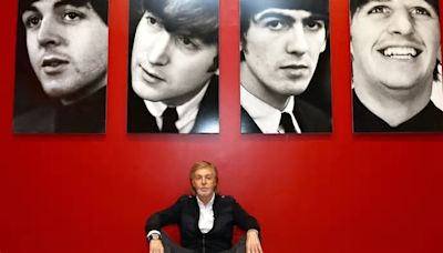 Sir Paul McCartney sits below portraits of his Beatles bandmates as he launches photo exhibition in New York