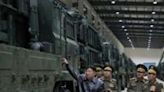North Korean leader Kim Jong Un (L) inspects missile launcher vehicles at an undisclosed location in North Korea