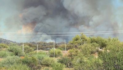 Residents in parts of Arizona’s most populous county asked to evacuate as a wildfire threatens homes