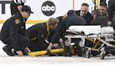 Referee Steve Kozari taken off ice on stretcher after collision with Lightning's Haydn Fleury