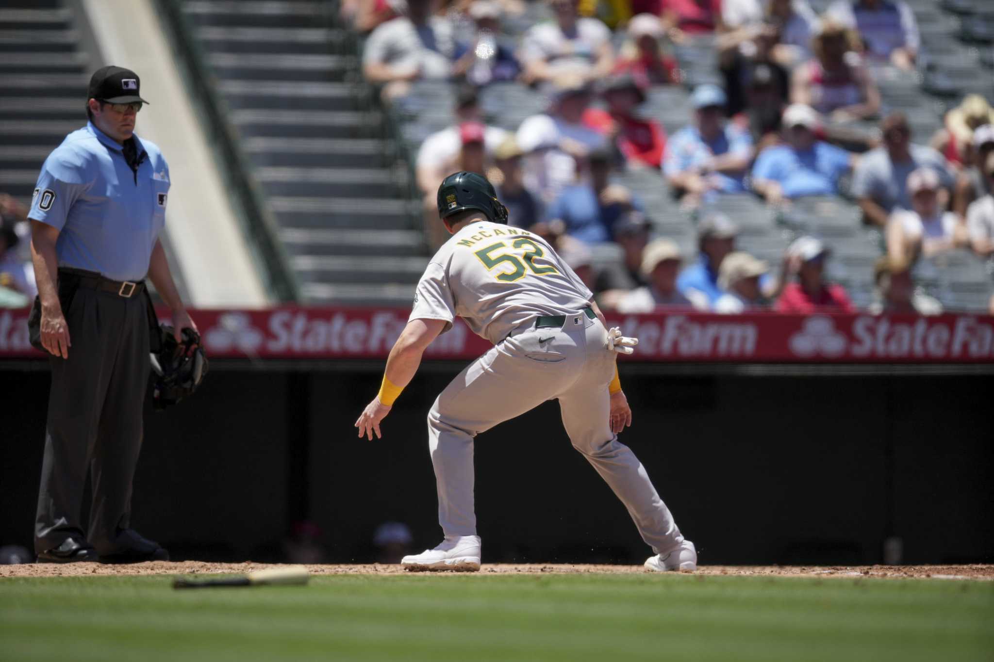 Oakland's Kyle McCann called out after missing home plate and then making contact with a teammate