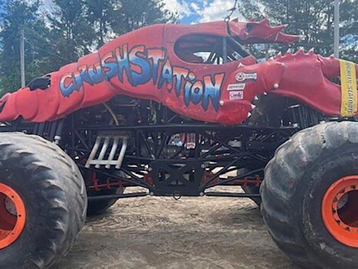 Lobster-themed monster truck clips aerial power line, toppling utility poles in spectator area
