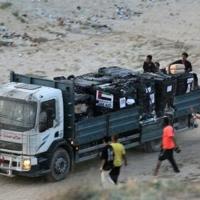 Palestinians rush a truck as it transports humanitarian aid from the US-built Trident Pier, near Nuseirat in the central Gaza Strip