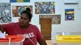 A woman drops her ballot paper into a box as the Solomon Islands general election begins