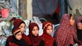 Palestinians, some in traditional embroidered dresses, gather on Eid al-Adha in southern Gaza's Khan Yunis city