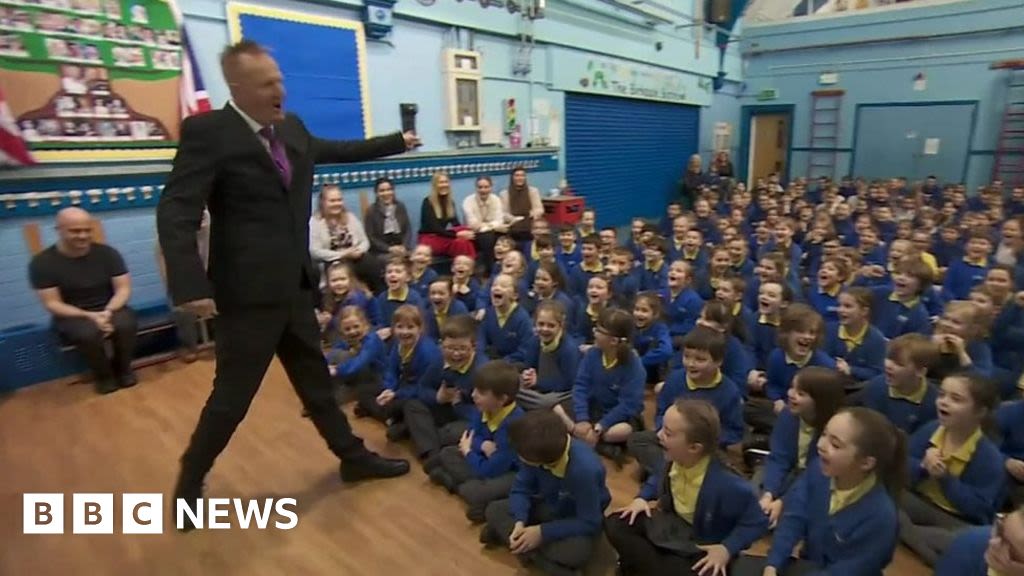 Head teacher saved by defibrillator makes emotional return to school